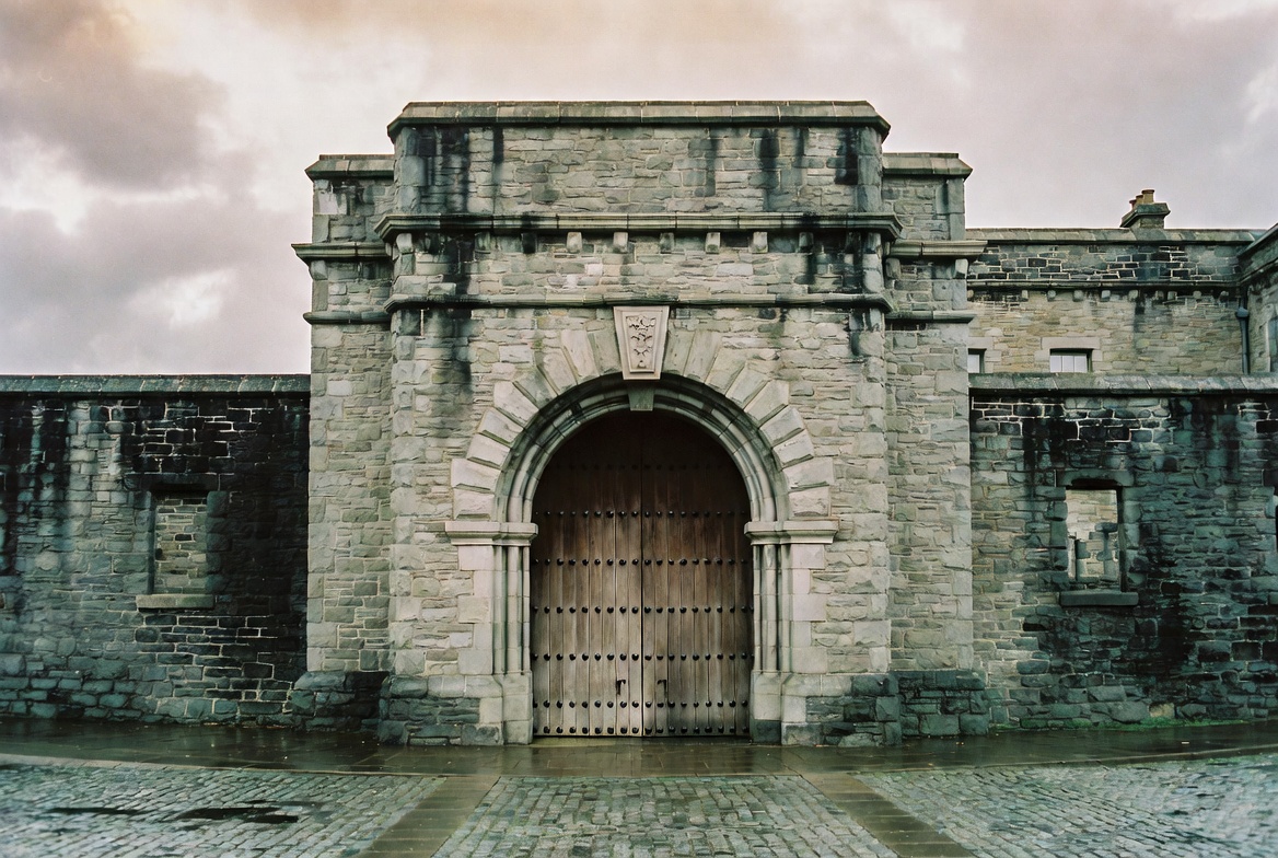 The cobbled forecourt and limestone facade of Kilmainham Gaol at first light, photographed for Celtic Penitentiary.