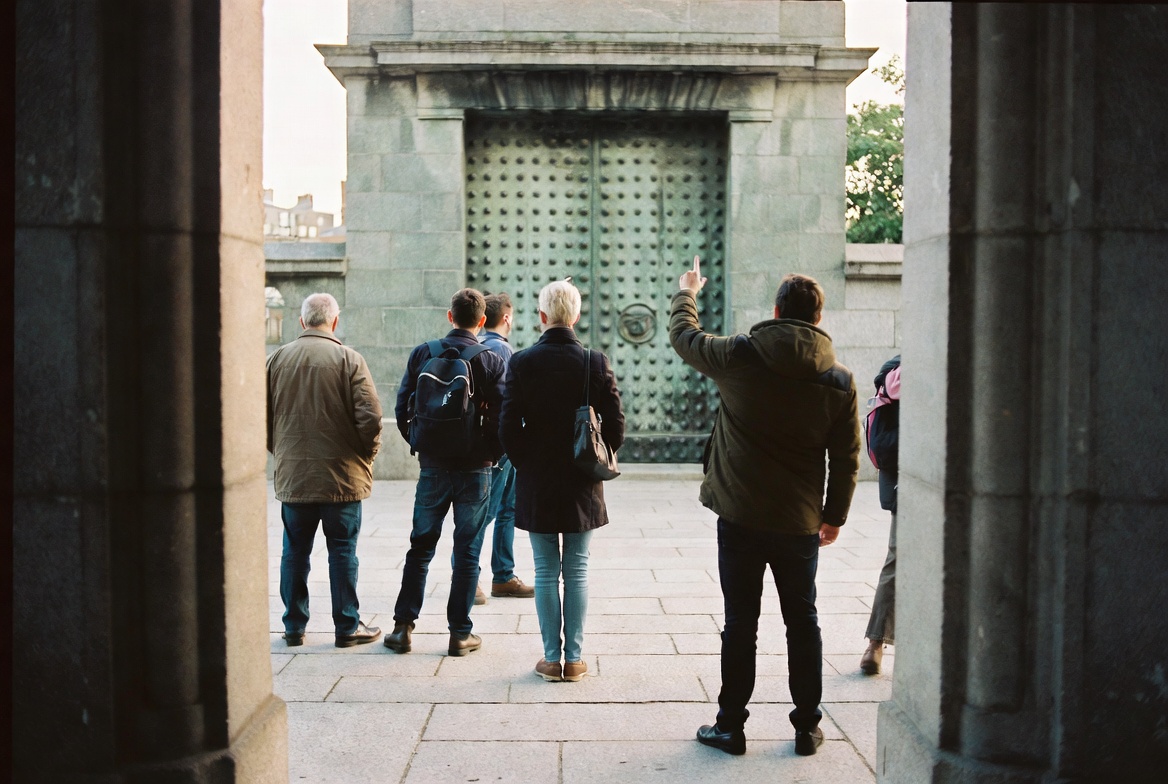 Walkers under the entrance arch of Dublin Castle's Cork Hill gate.
